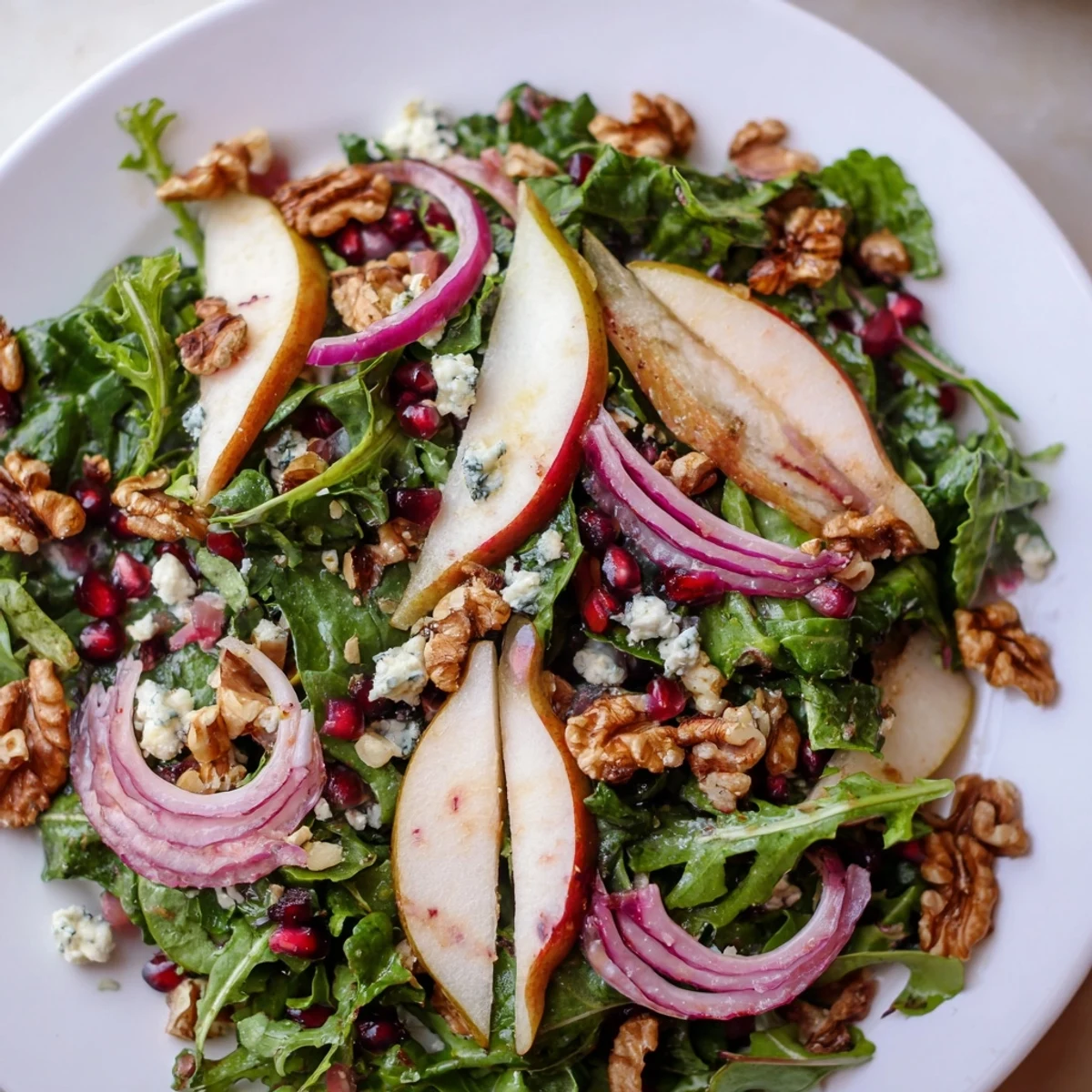 Vibrant Winter Green Salad with pear and walnuts, tossed and ready to serve with a light vinaigrette.