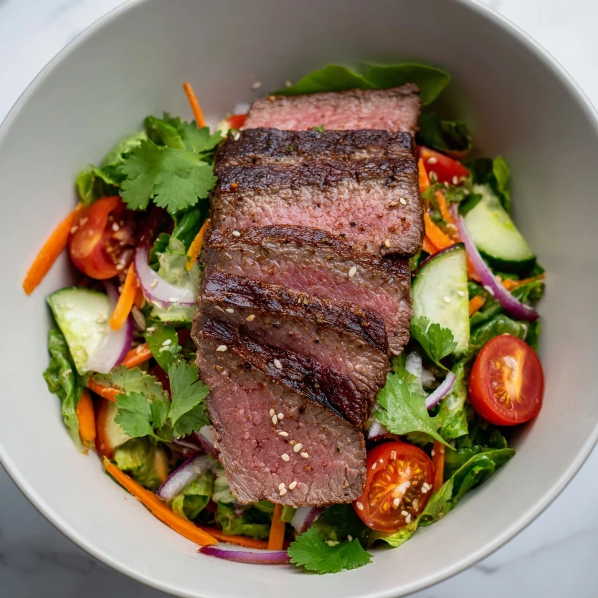 Tender beef slices with juicy tomatoes and creamy avocado garnish are drizzled with zesty ginger lime dressing on this Beef Salad Bowl. 