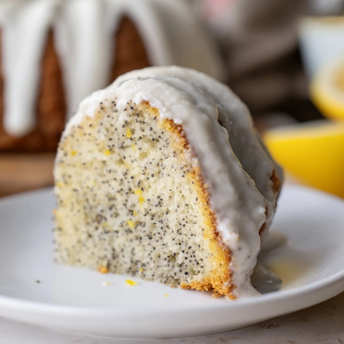 Freshly baked Lemon Poppy Seed Bundt Cake with a creamy lemon glaze dripping down the fluted ridges.