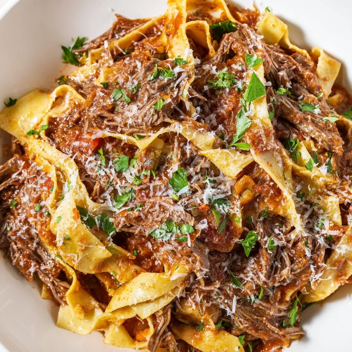 Slow Cooker Ragu Sauce with Beef simmering in a ceramic insert, with tender shredded beef and a rich, deep red tomato base.