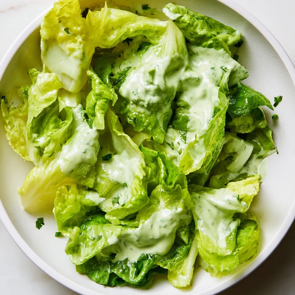 Freshly tossed Green Salad with Green Goddess Dressing in a rustic bowl, topped with toasted pumpkin seeds and fragrant chopped herbs.