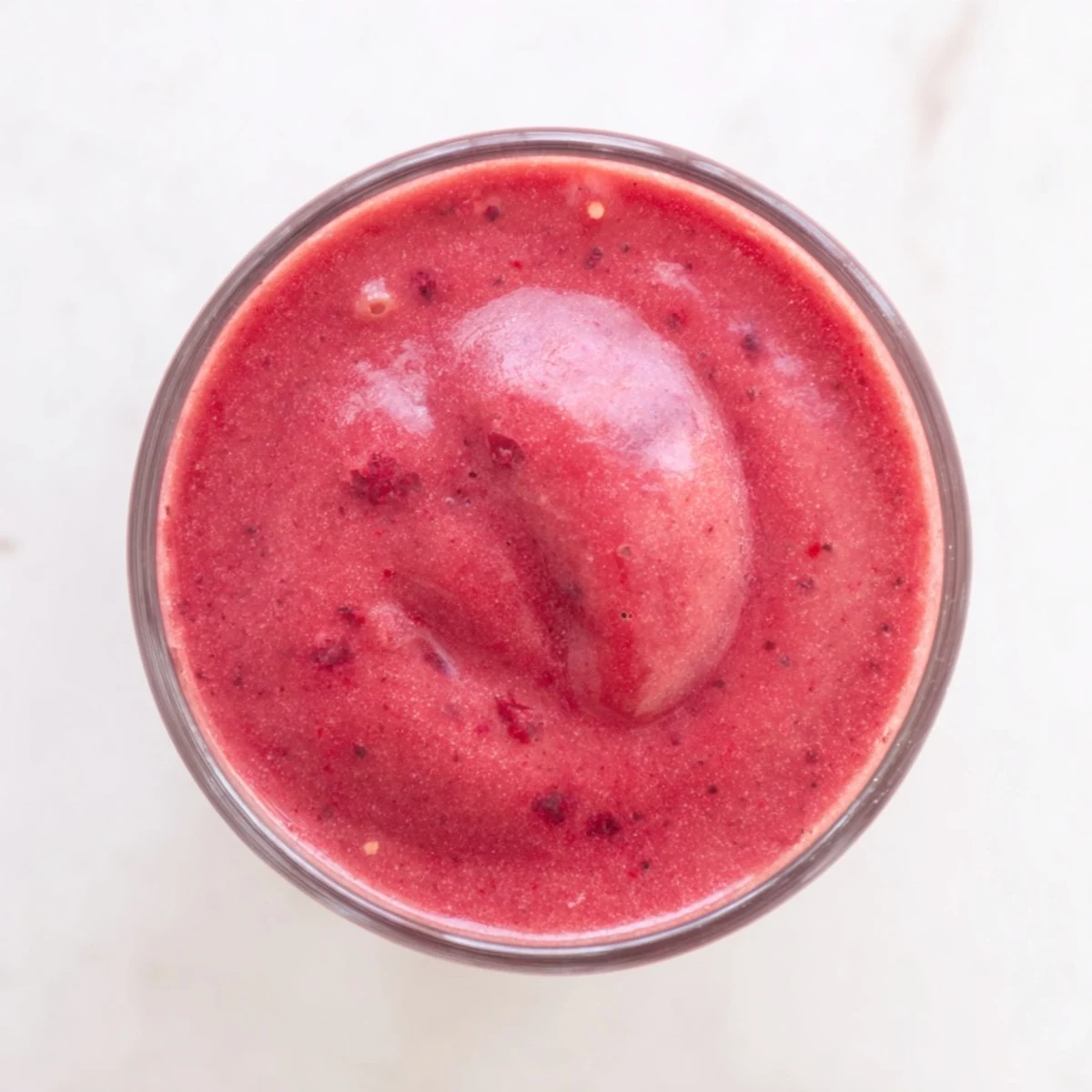 Pouring the creamy Valentine Red Berry Smoothie from a blender into a glass, berries swirling, evoking a sweet-tart, refreshing American breakfast beverage.