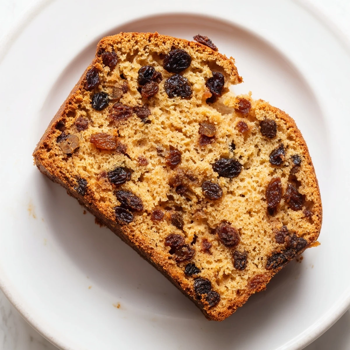 Freshly baked Irish Tea Cake on a wire rack, featuring golden crust and plump, tea-soaked dried fruit.