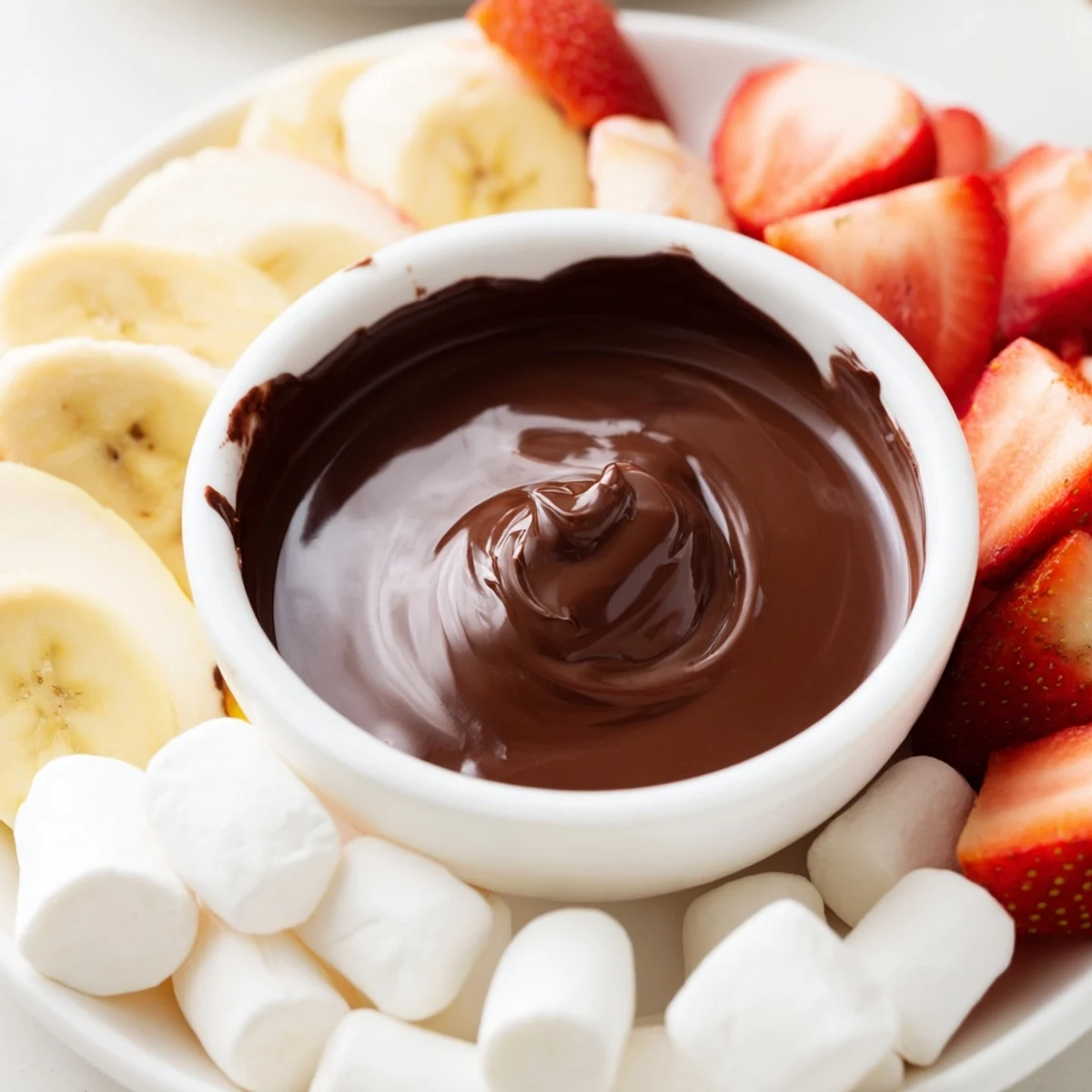 For a cozy date night, Romantic Chocolate Fondue with Marshmallows and Fruit pairs with skewered fruit, marshmallows, and a sparkling drink.