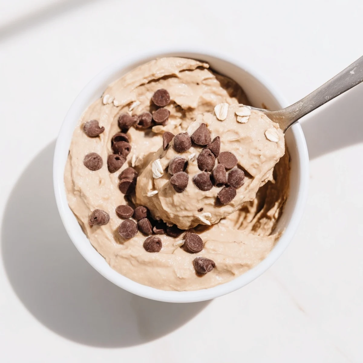 Served in a rustic bowl, Chocolate Chip Cookie Dough Hummus with apple slices for dipping.