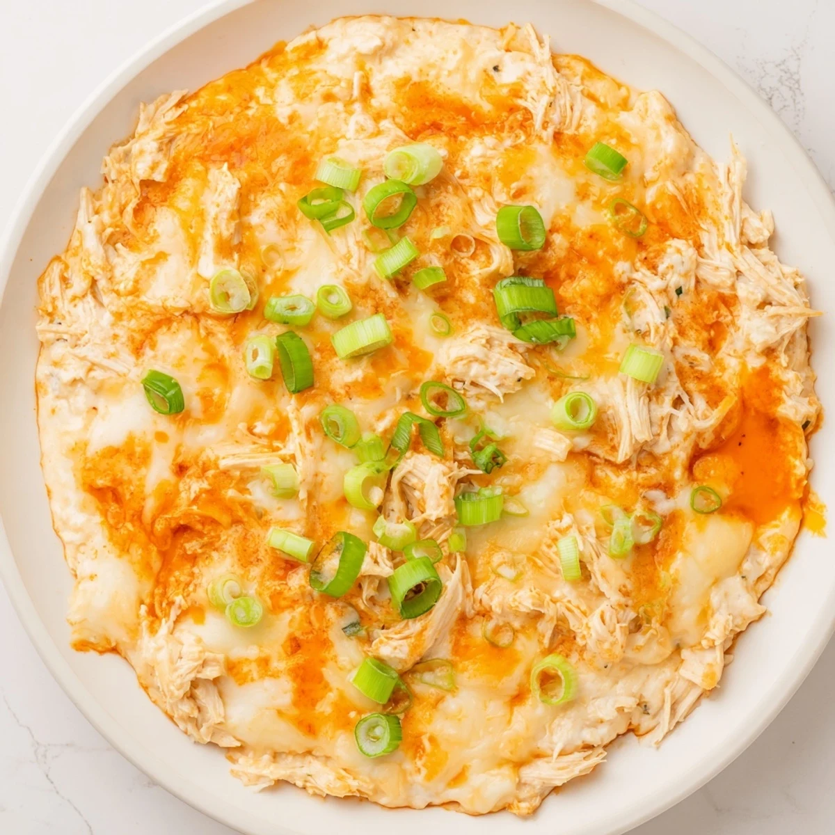 A colorful serving platter with Spicy Buffalo Chicken Dip, fresh celery sticks, and crunchy tortilla chips for game day.
