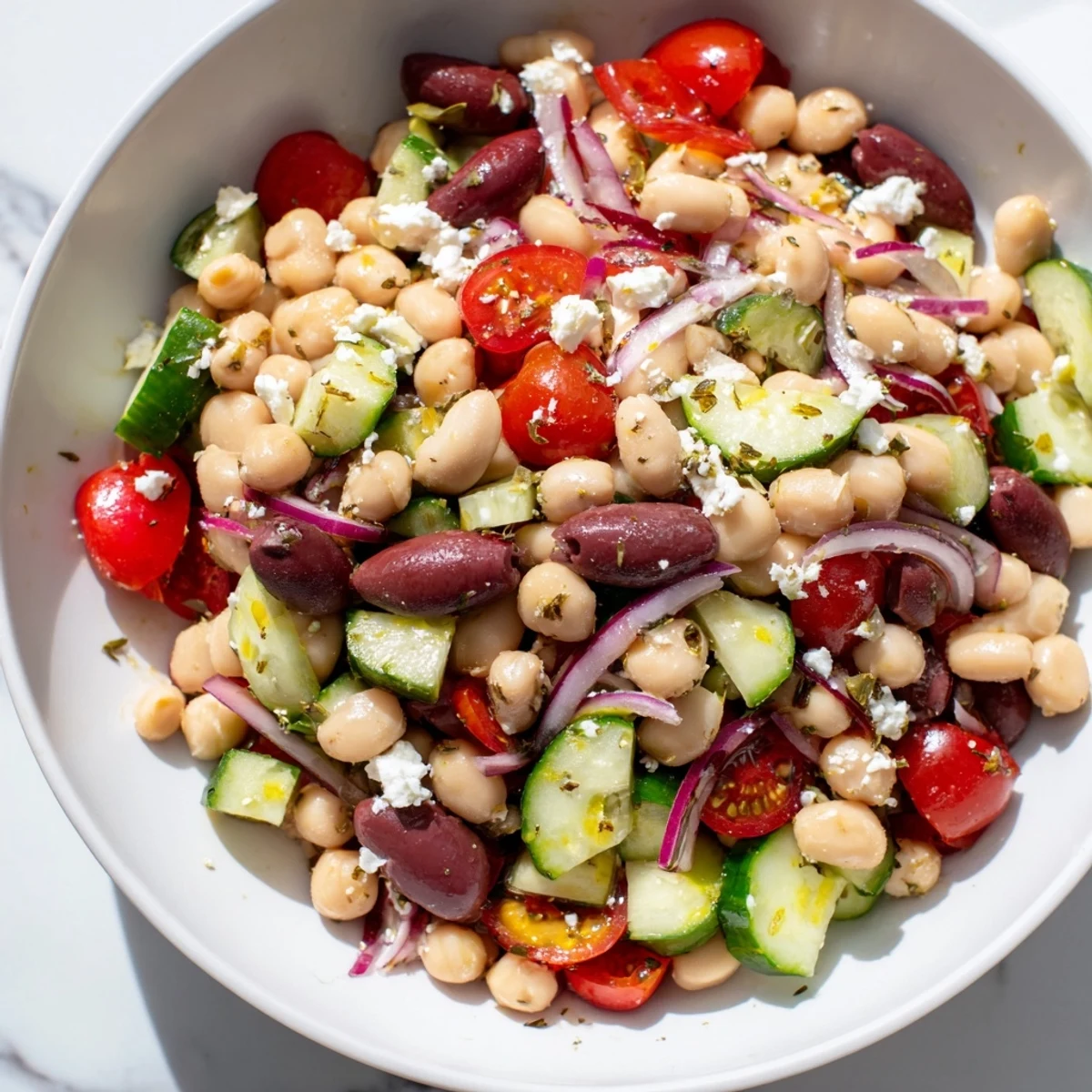 A close-up of the Mediterranean Dense Bean Salad with colorful beans, cherry tomatoes, and fresh herbs in a rustic bowl.