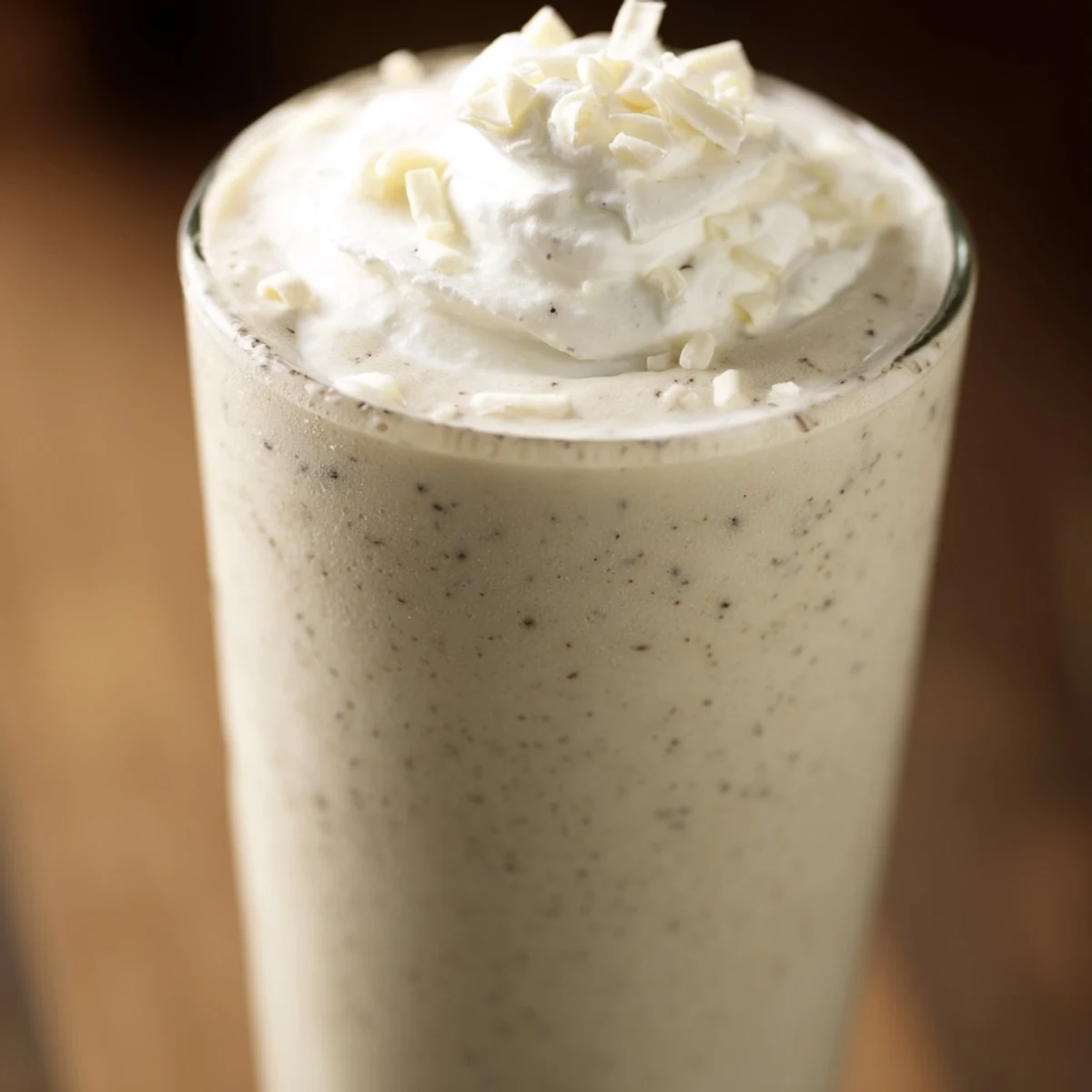 Homemade Vanilla Bean Frappuccino topped with white chocolate shavings and frothy texture.