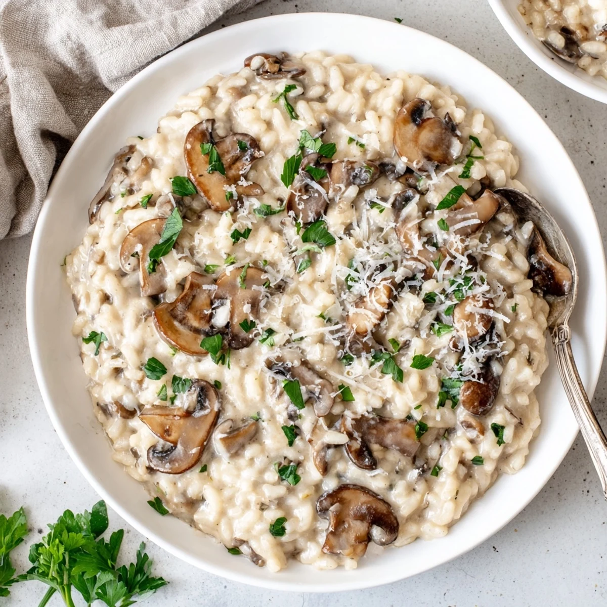Steaming Creamy Mushroom Risotto topped with fresh parsley and extra Parmesan on a rustic wooden table.