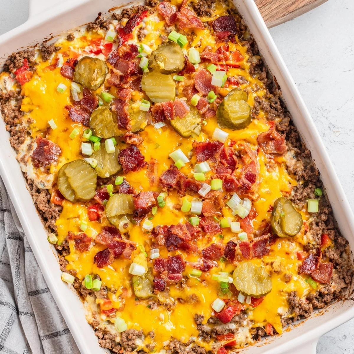 A close-up of the Low Carb Bacon Cheeseburger Casserole with melted cheddar and crispy bacon on top.