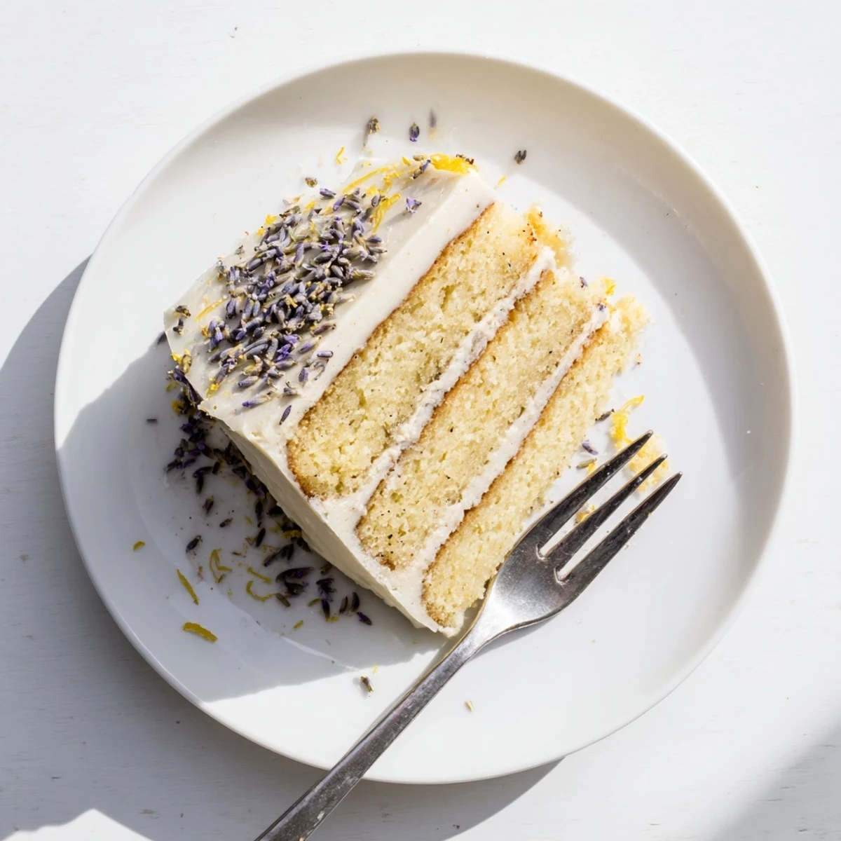 Close-up of London Fog Cake with Earl Grey & Lavender shows creamy vanilla bean frosting and lemon zest.