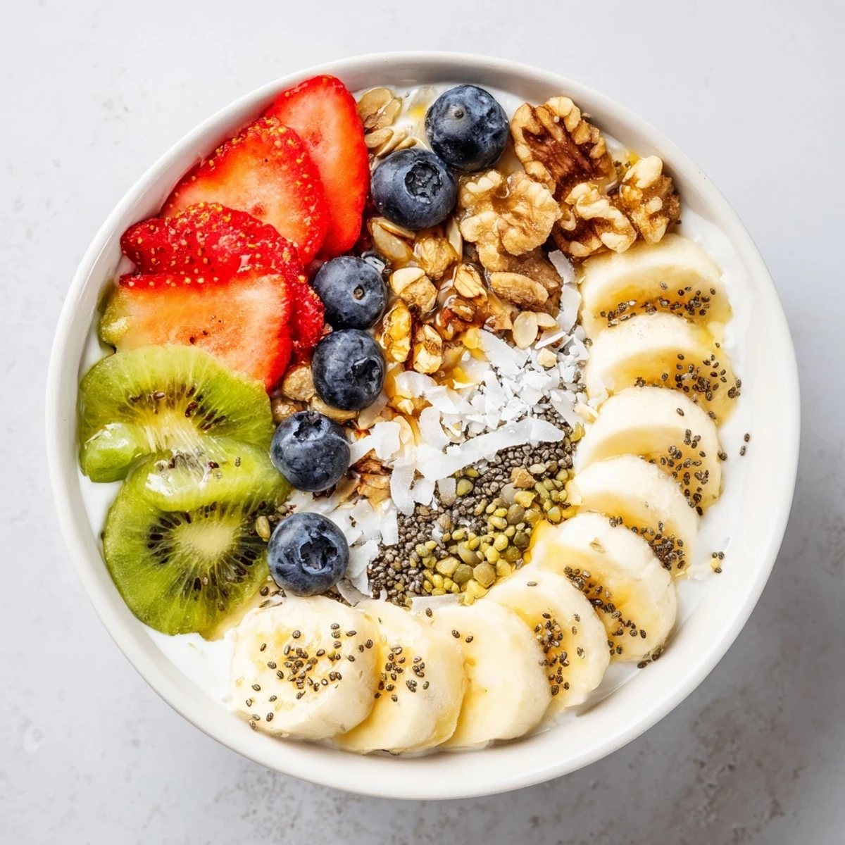 A close-up of the Healthy Breakfast Bowl showing creamy Greek yogurt topped with sliced banana, strawberries, blueberries, and crunchy granola.