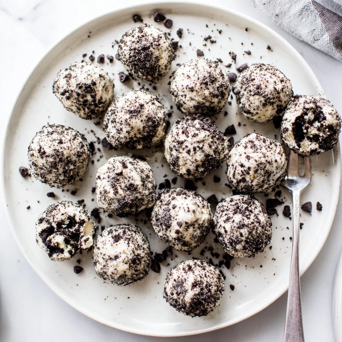 No-bake Cream Cheese Oreo Protein Balls on a chilled tray, drizzled with chocolate for an indulgent yet healthy bite.
