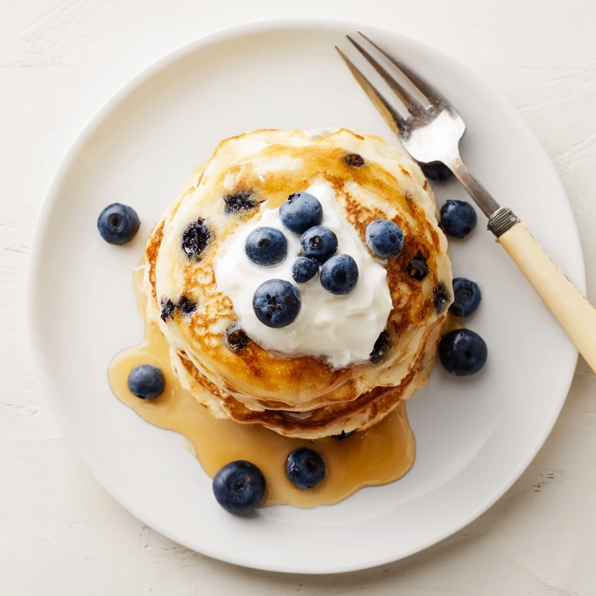 Homemade Greek yogurt blueberry pancakes drizzled with honey and sprinkled with powdered sugar