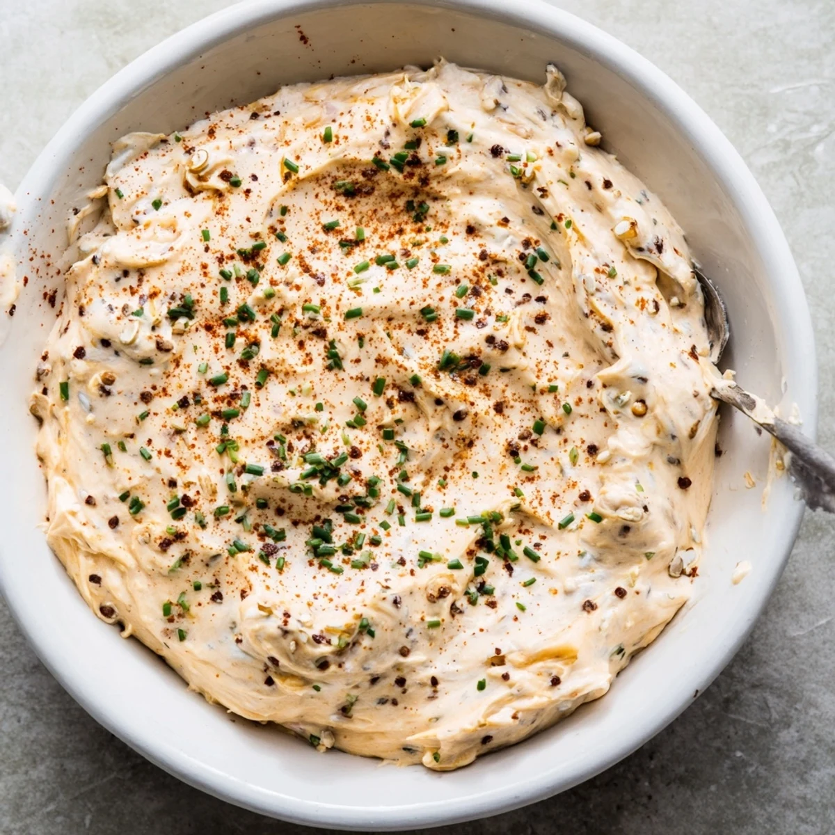 Creamy savory pretzel dip topped with fresh chives served beside warm soft pretzels