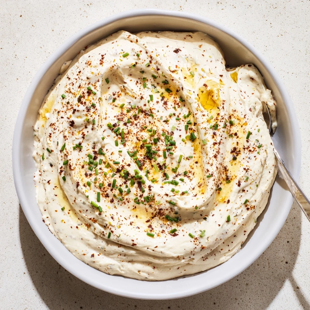 Rich and tangy savory pretzel dip garnished with green onions, perfect for party snacks