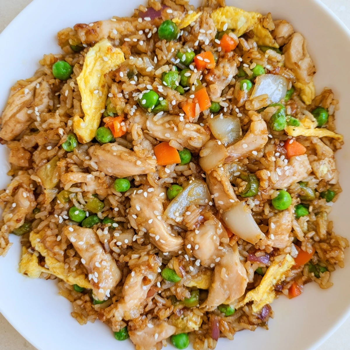 Wok-tossed chicken fried rice featuring tender meat, crisp veggies, and golden egg omelette ribbons