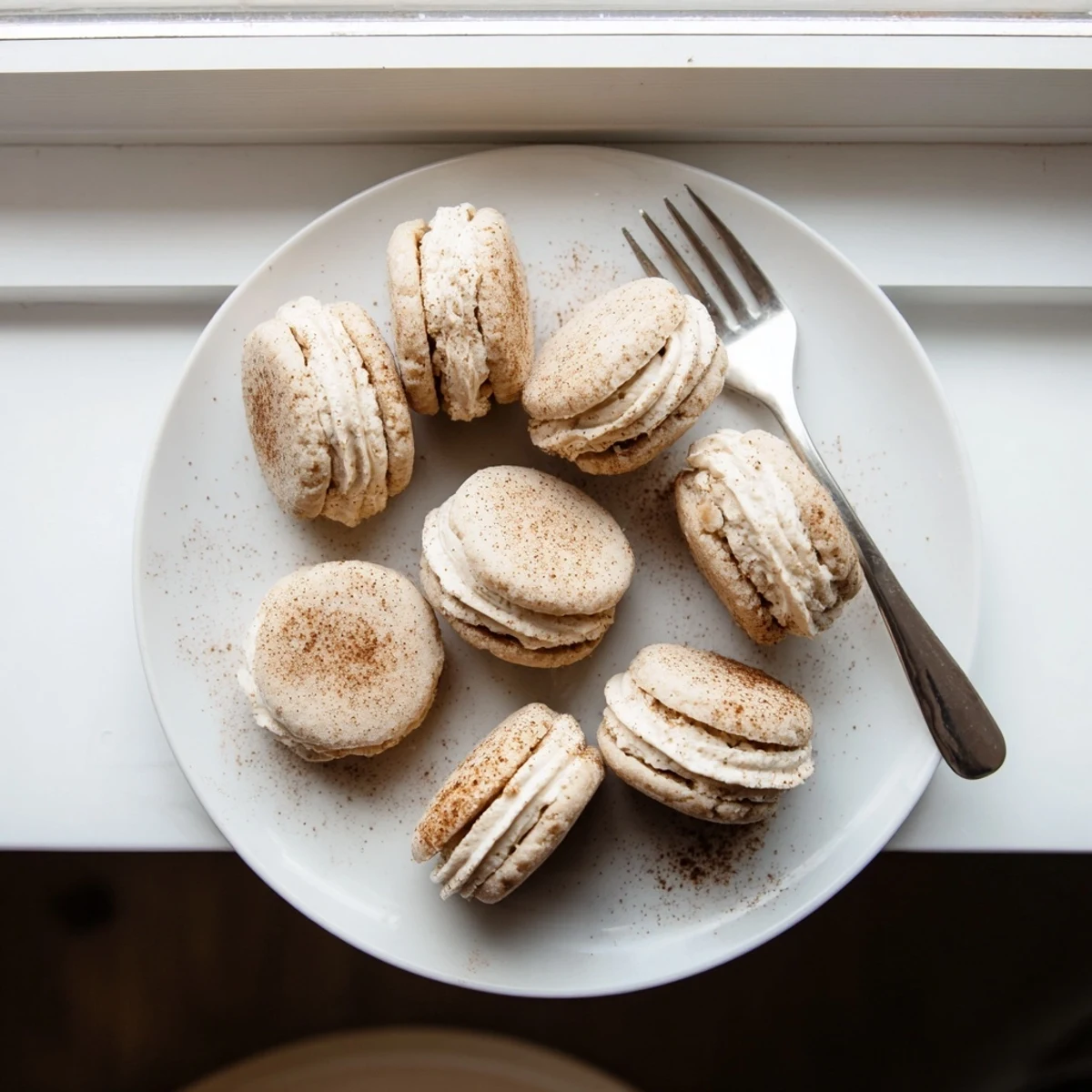 Buttery shortbread cookies sandwiched together with chai-spiced cream filling alongside a steaming mug of tea