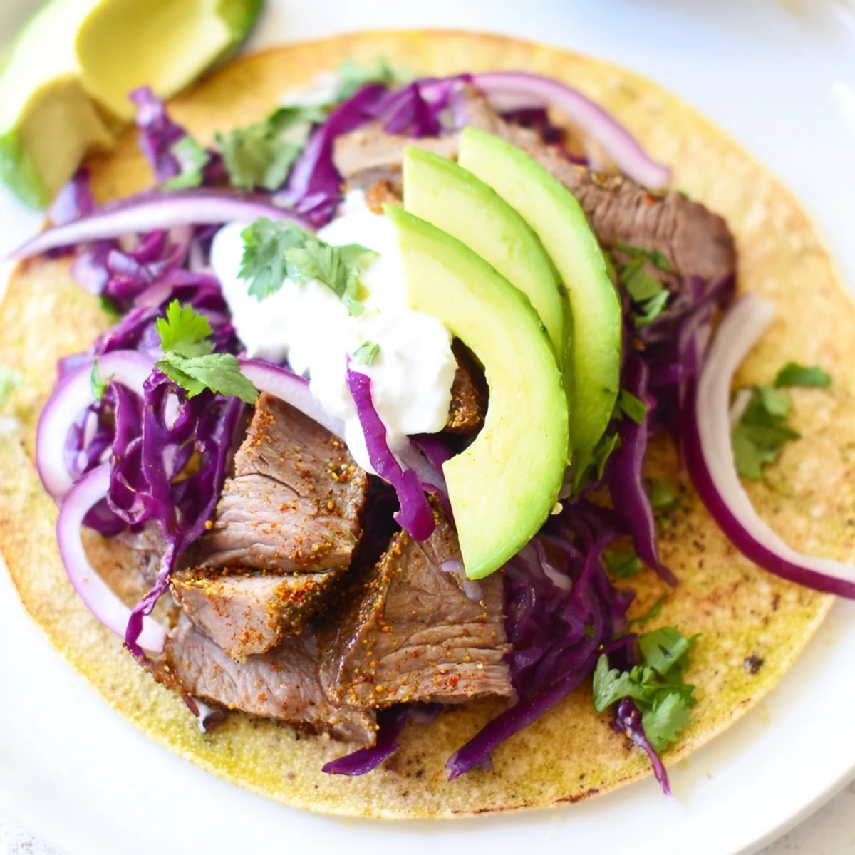 Succulent cumin crusted leg of lamb tacos topped with fresh avocado and cilantro