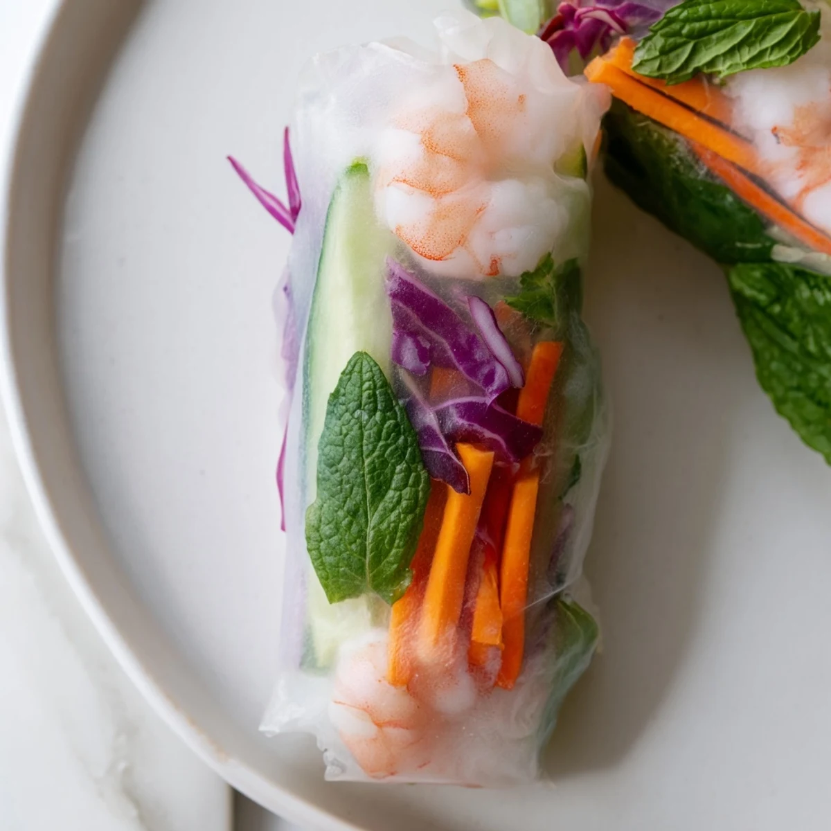 Fresh Thai shrimp rolls with peanut sauce featuring pink shrimp and crisp vegetables in translucent rice paper