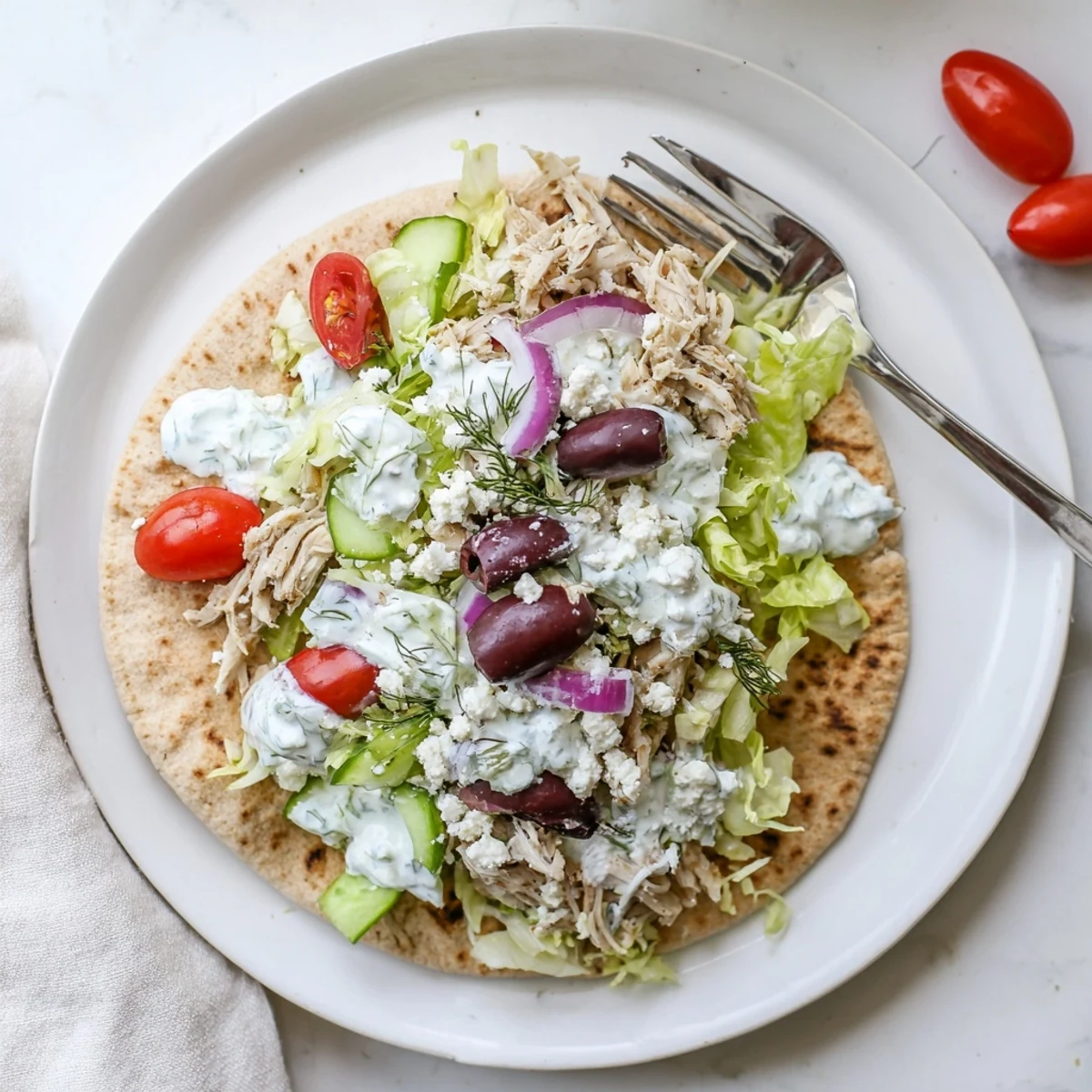 Slow cooker Greek chicken pitas stuffed with tender meat and crisp vegetables in warm pita bread