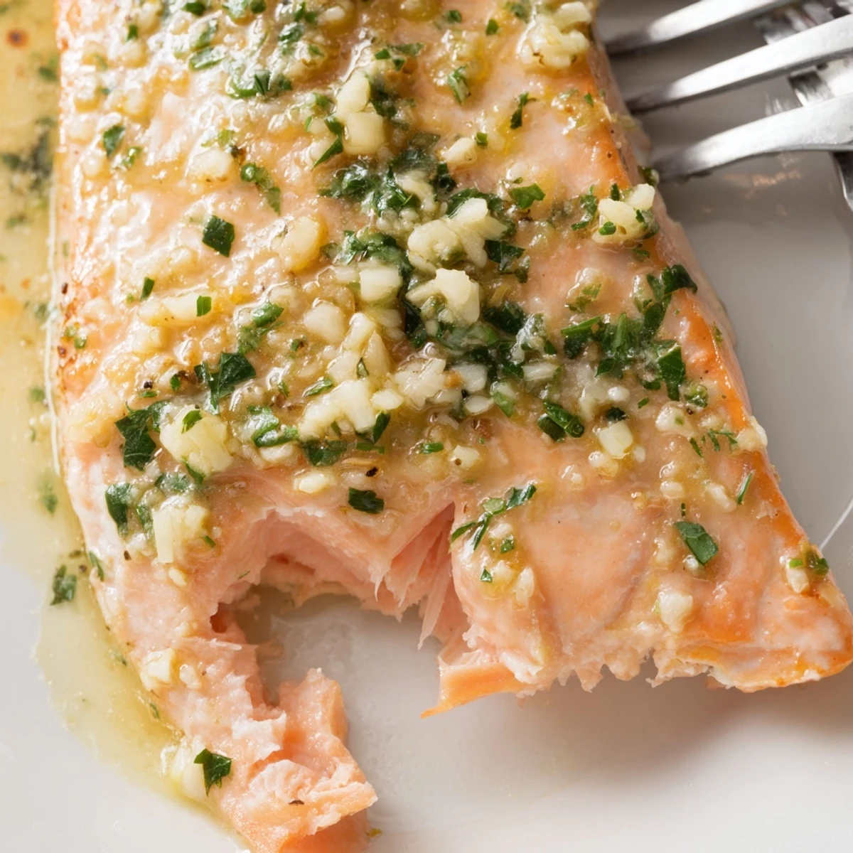 Tender oven roasted salmon with melted garlic butter sauce and chopped parsley topping
