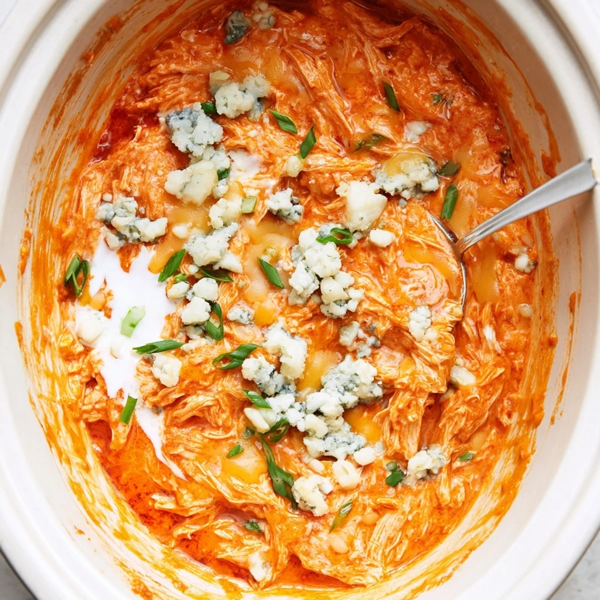 Creamy Crockpot Buffalo Chicken Dip bubbling with melted cheddar and mozzarella cheese