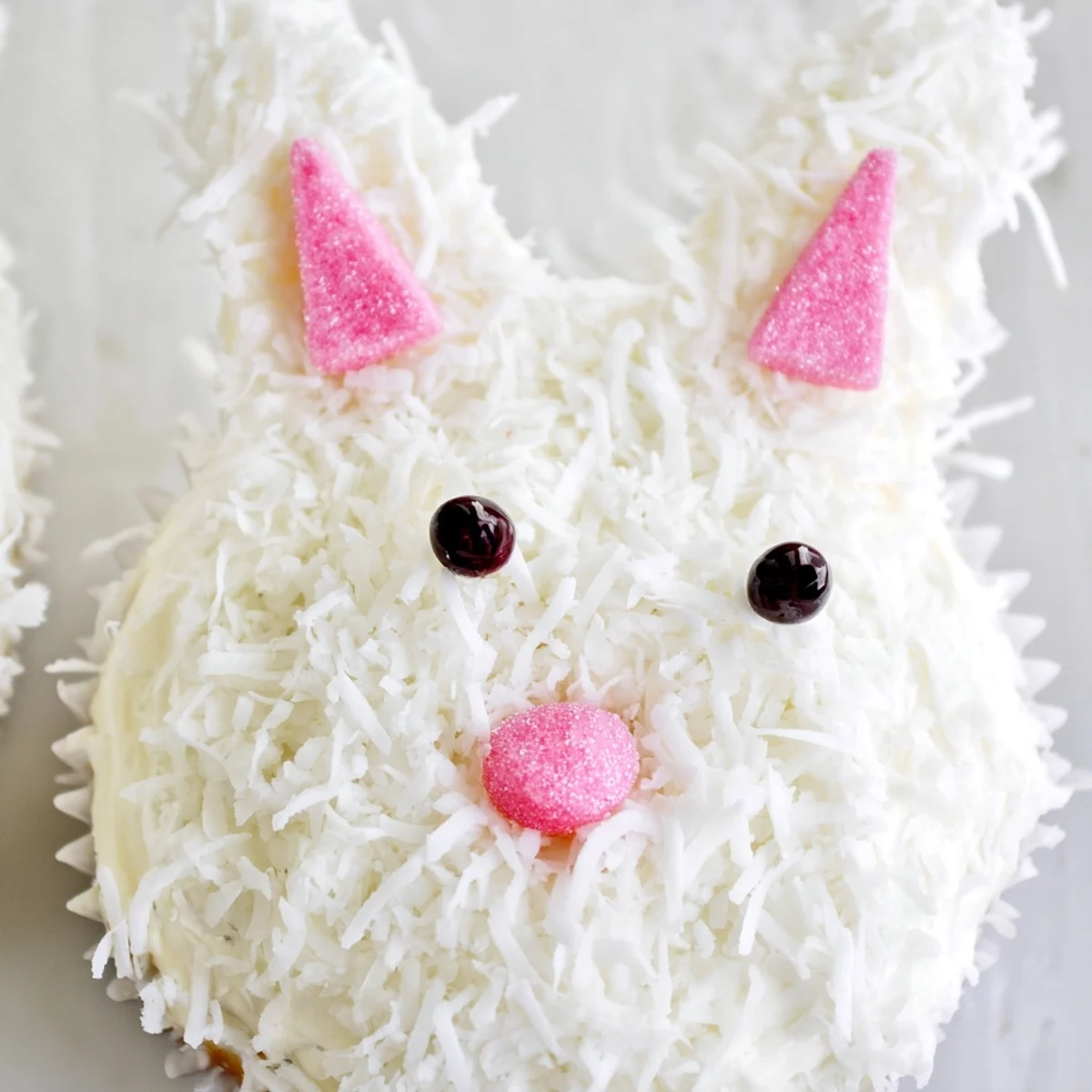 Adorable vanilla bunny cupcakes with fluffy coconut fur and pink marshmallow ears for Easter