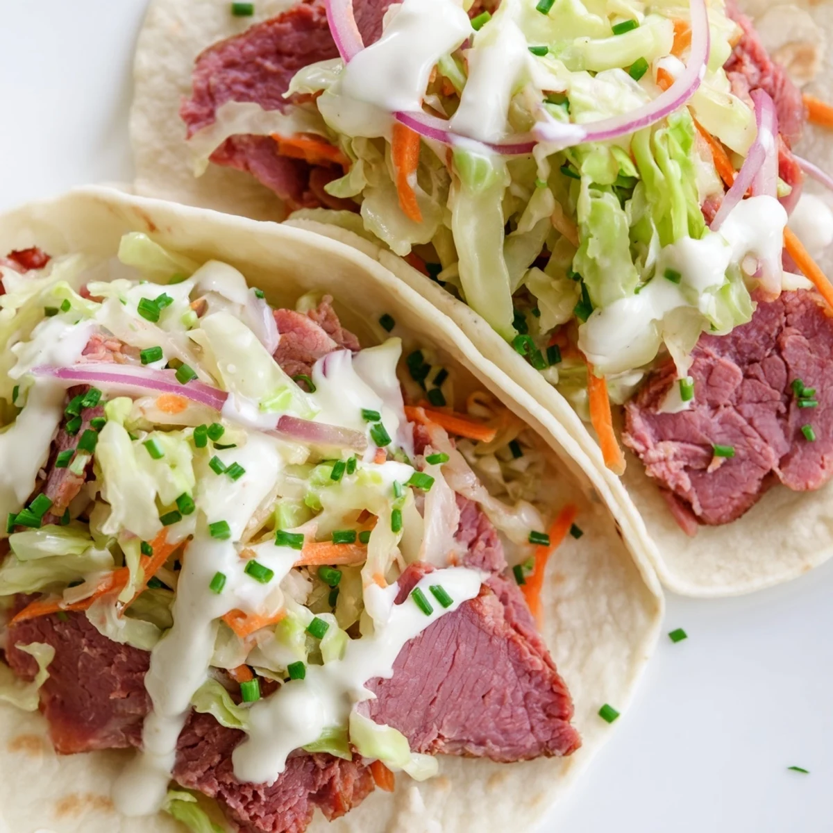 Soft flour tortillas filled with tender corned beef and crisp cabbage slaw drizzled with creamy horseradish sauce