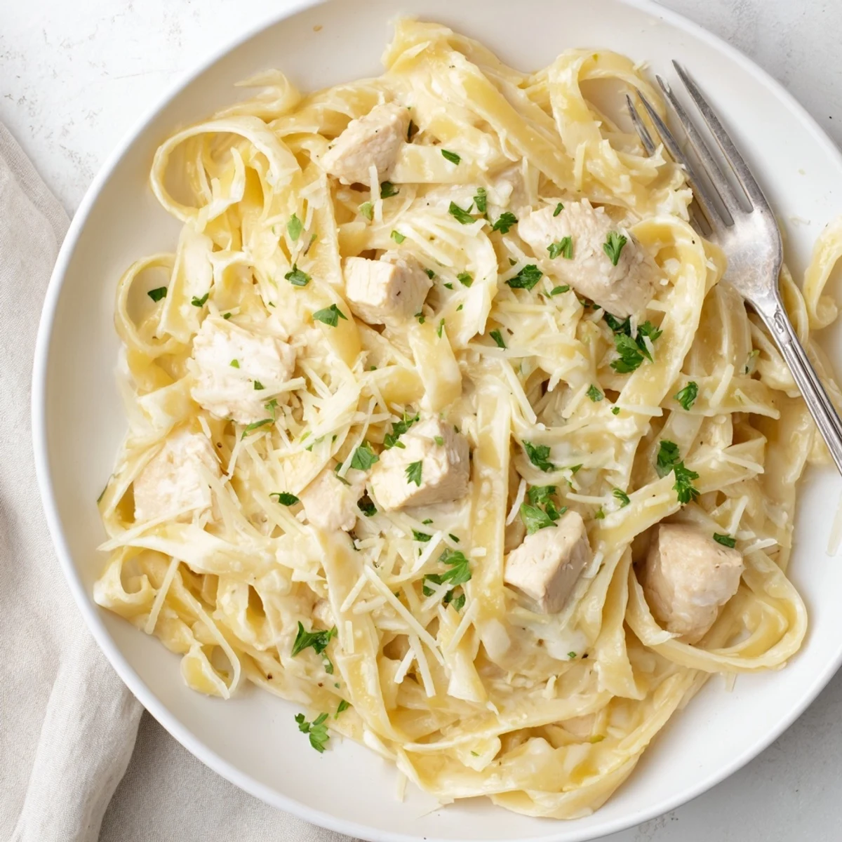 Italian-American comfort food featuring fettuccine noodles and bite-sized chicken breasts in a velvety cream and parmesan sauce