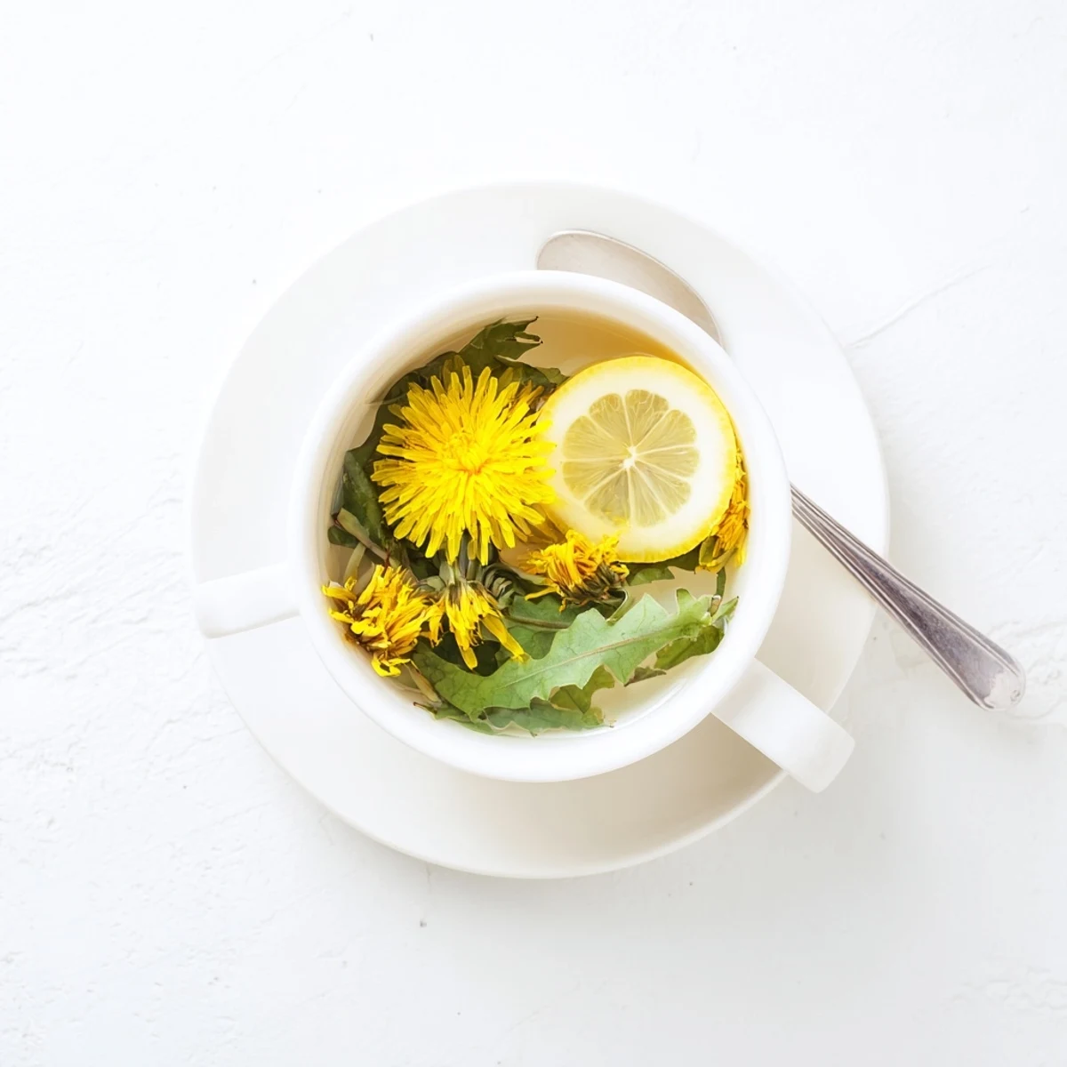 Hand pouring hot water over dried dandelion flowers to brew a soothing herbal tea in clear teapot