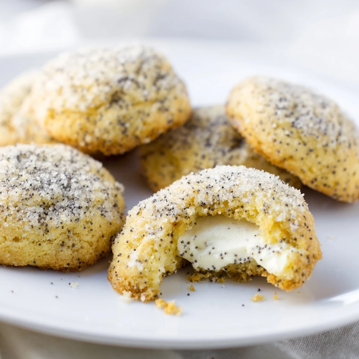 Soft golden lemon poppy seed cheesecake cookies with creamy white center and sugary coating