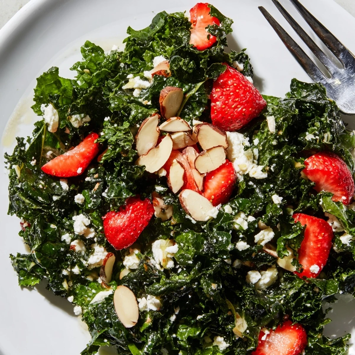 Vibrant summer kale salad drizzled with lemon-honey dressing beside sliced avocado and cherry tomatoes