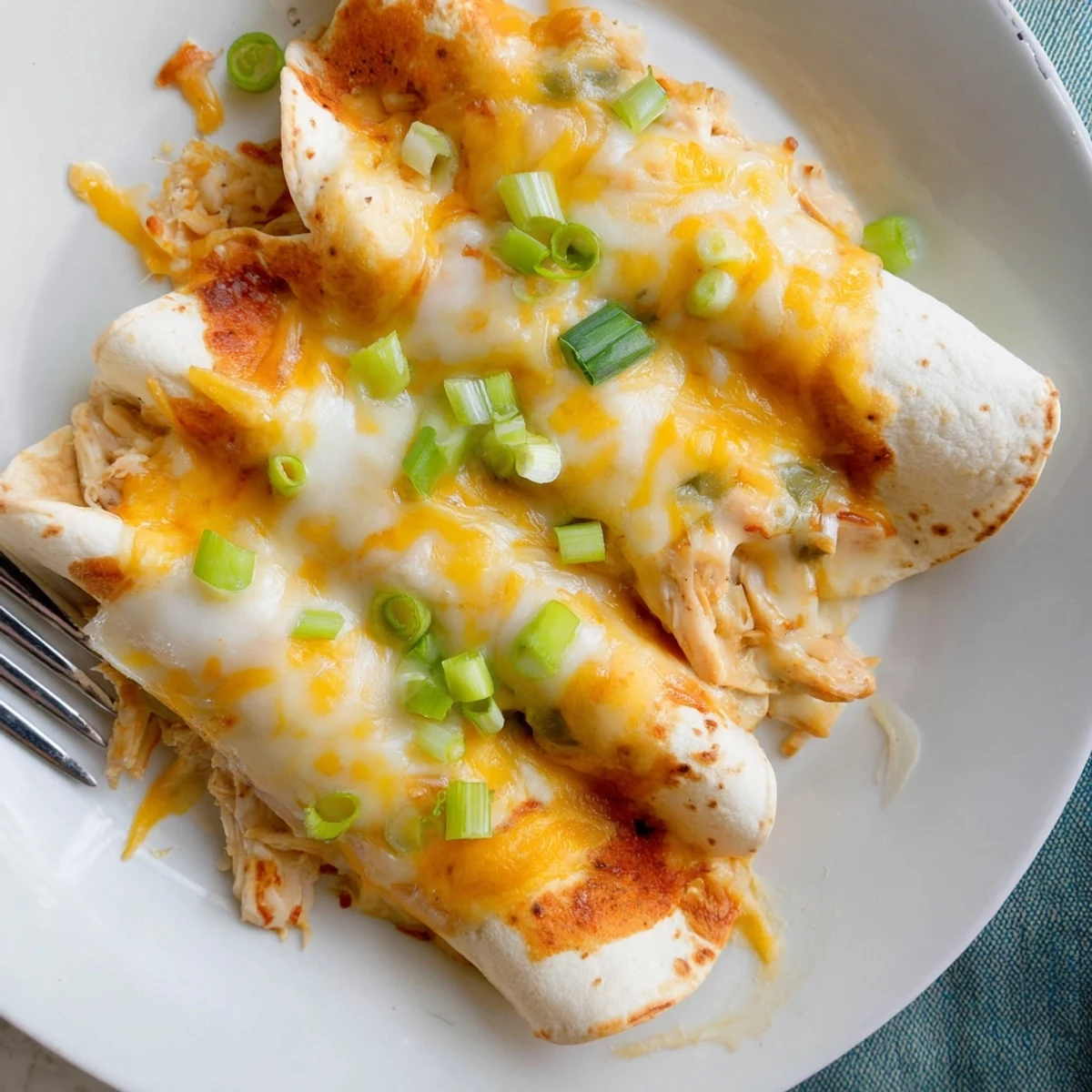 Baked in a casserole dish, Creamy White Chicken Enchiladas ooze cheesy filling.