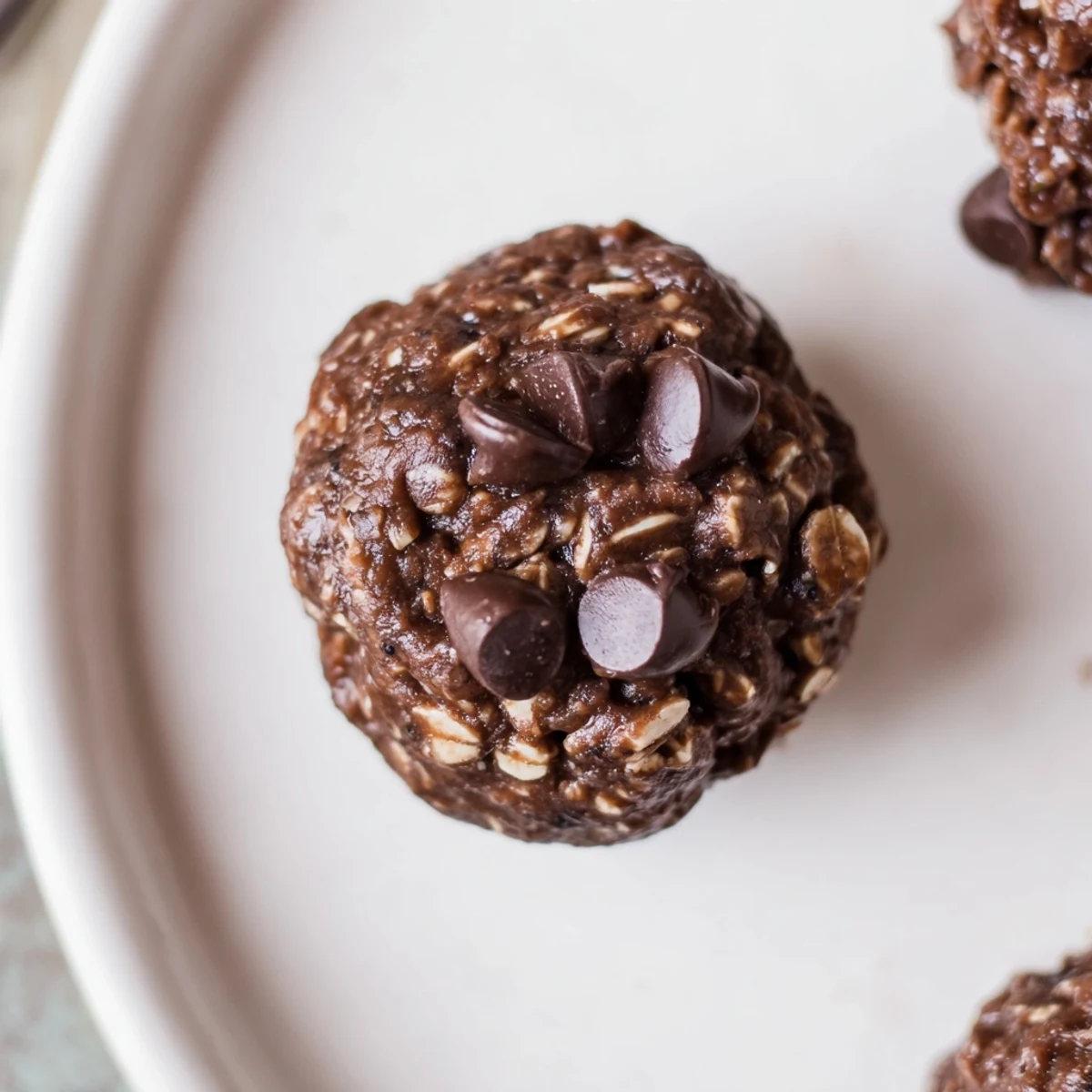 Brownie Protein Bites arranged on parchment, glossy chocolate chips and dense texture