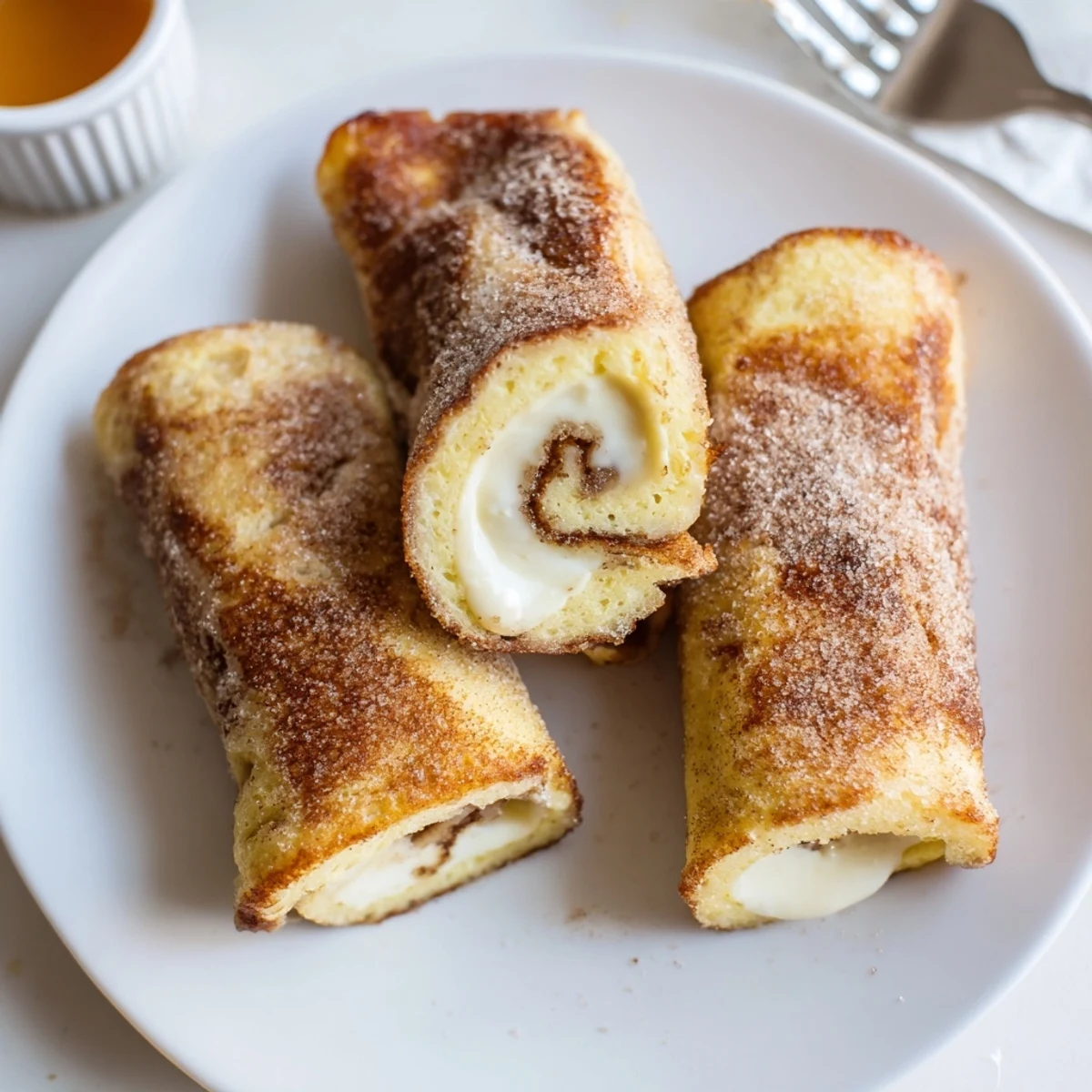 Cinnamon Roll French Toast Roll Ups, golden brown and warmly spiced, served with syrup