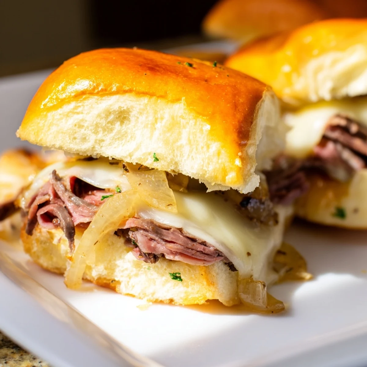 Golden French dip sliders with melted provolone served alongside rich beef au jus dipping sauce