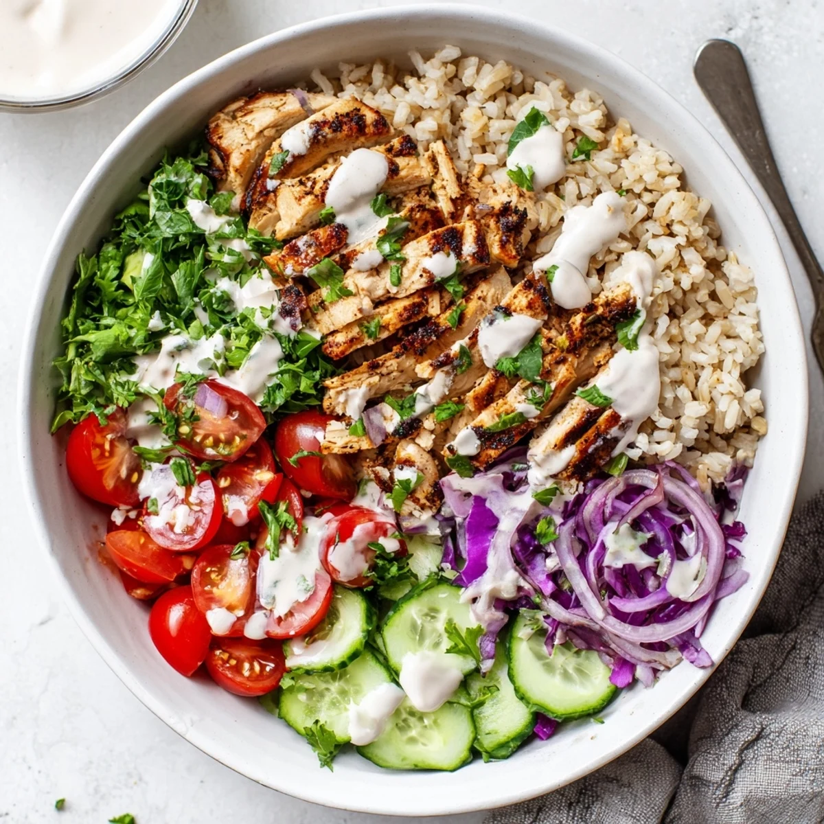 Nutritious chicken shawarma bowl arranged with brown rice fresh greens and protein-rich sliced chicken topped with tangy yogurt tahini dressing