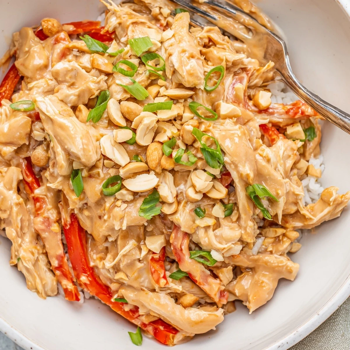 Aromatic, tender Crockpot Thai Peanut Chicken served over rice noodles with cilantro