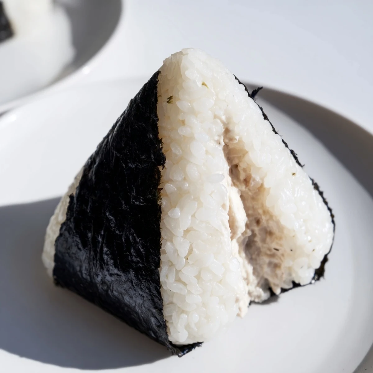Golden triangles of tuna mayo onigiri with savory filling and roasted seaweed