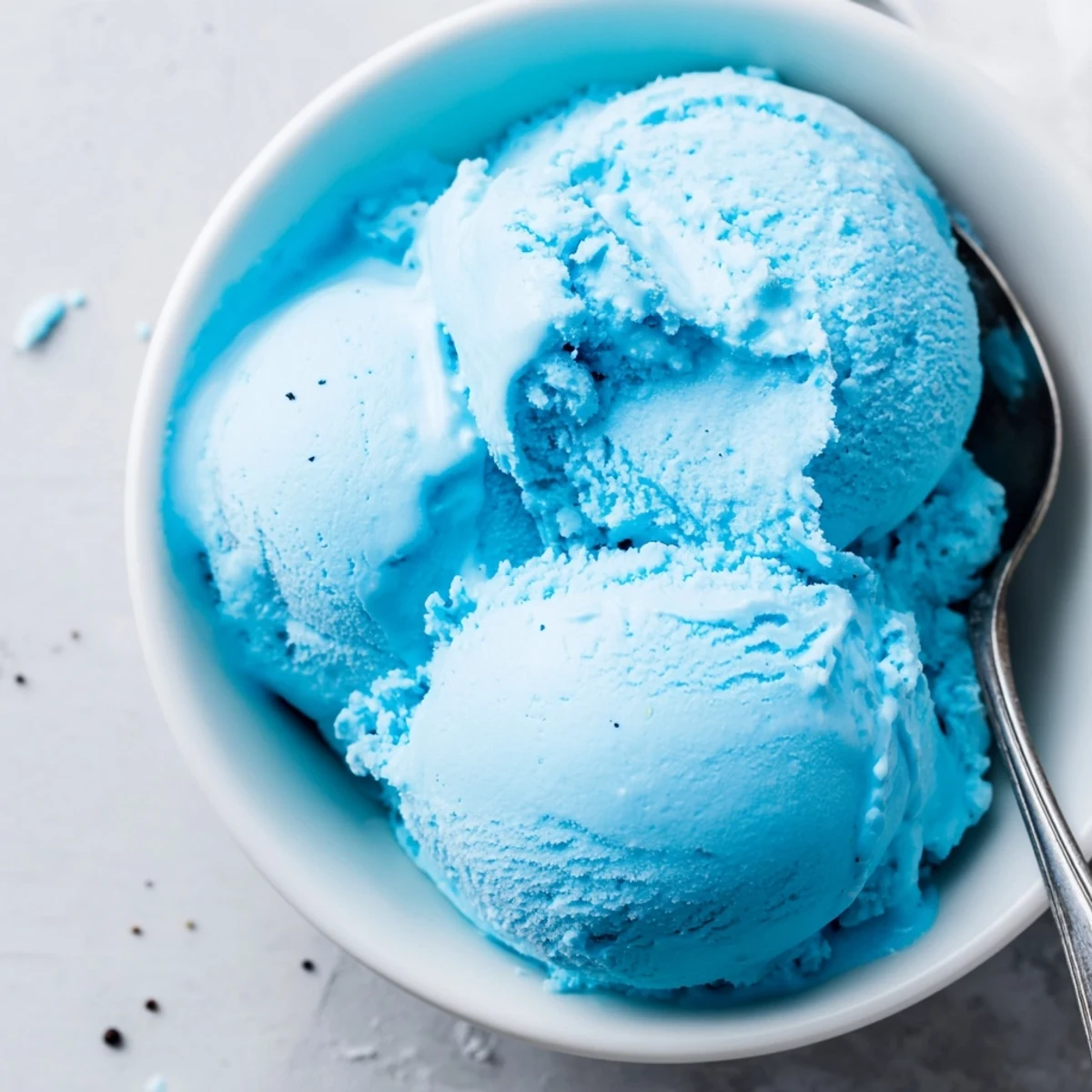Vibrant blue moon ice cream served in a bowl topped with colorful rainbow sprinkles