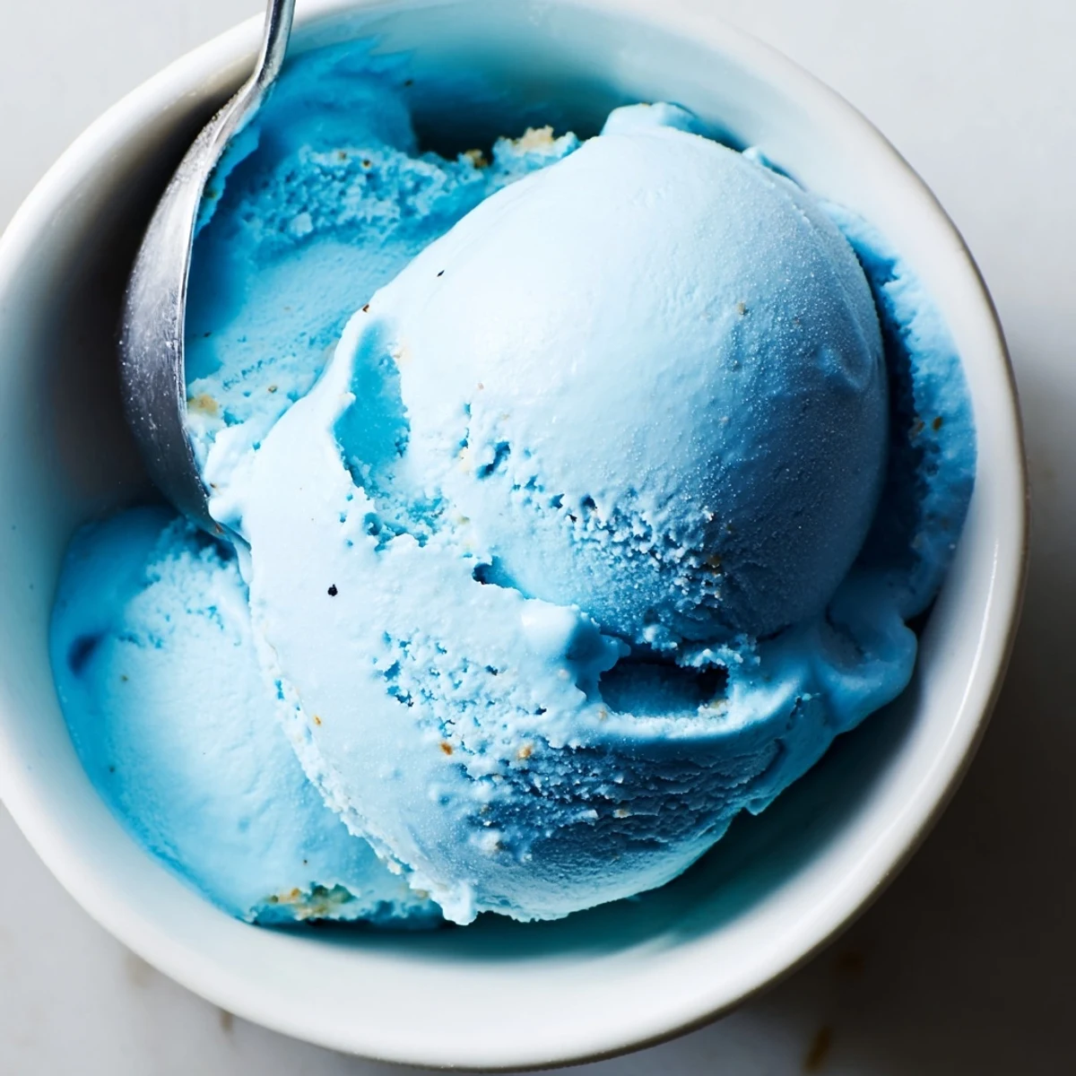 Creamy blue moon ice cream scooped into a crunchy waffle cone with bright blue color