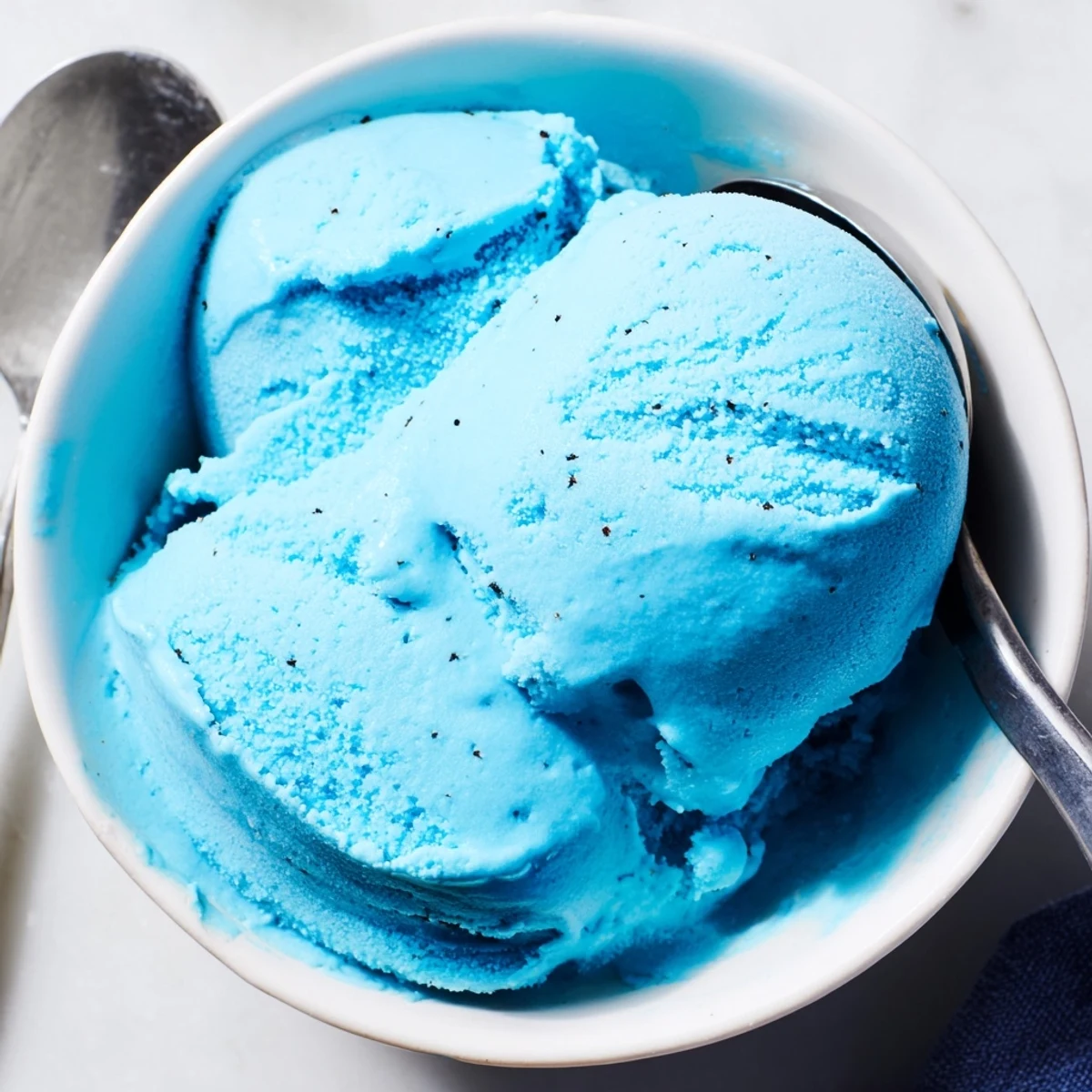 Smooth blue moon ice cream with a rich custard texture scooped into summer cones