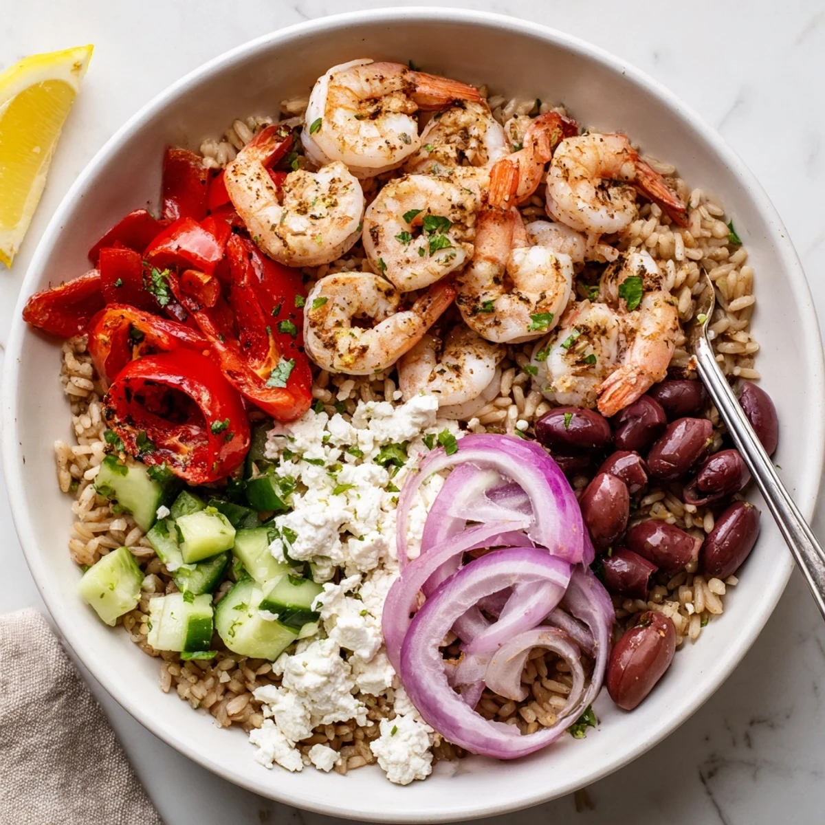 Sizzling Greek Shrimp Mediterranean Bowl drizzled with zesty lemon herb dressing over quinoa