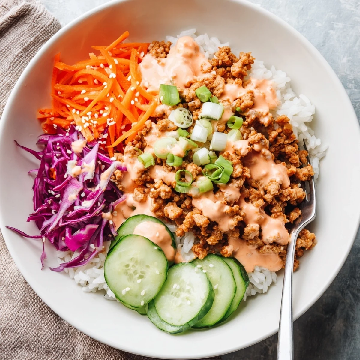 Ground Turkey Rice Bowls topped with crisp vegetables and drizzled with creamy Bang Bang Sauce